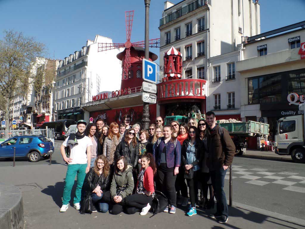 Gruppenbild der Studierenden und Dozenten und Dozentinnen vor dem Moulin Rouge in Paris.