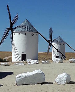 Weiße Windmühlen in Spanien vor blauem Himmel